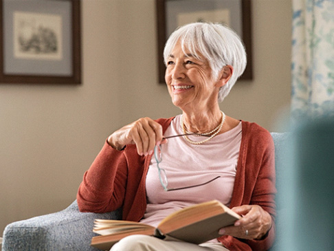 Woman reading and smiling with All-on-4 implants in Ledgewood, NJ