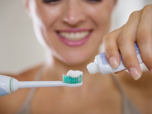 Woman brushing teeth to prevent dental emergencies