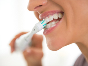 Woman with dental implant in Ledgewood brushing teeth