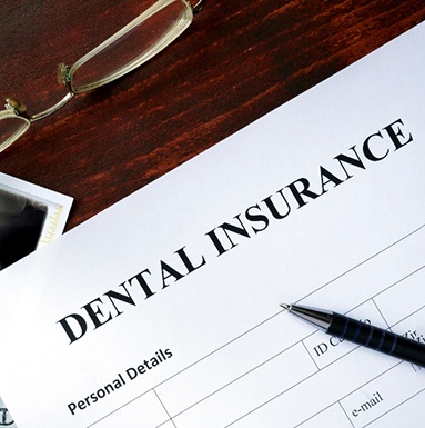 A closeup of a dental insurance form on a wooden table
