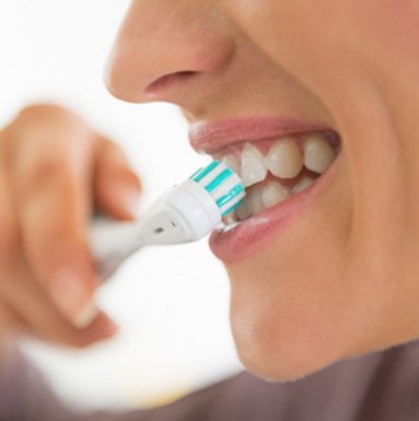 A closeup of a young woman brushing her teeth