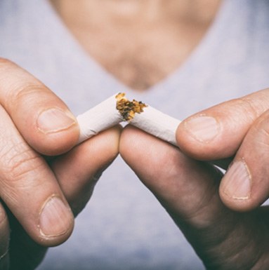 A man breaking a cigarette 