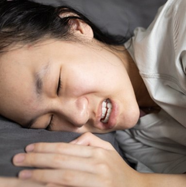 A woman grinding her teeth in her sleep