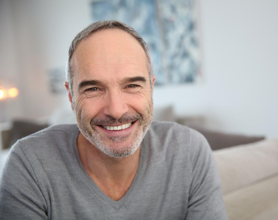 Man smiling after replacing missing teeth