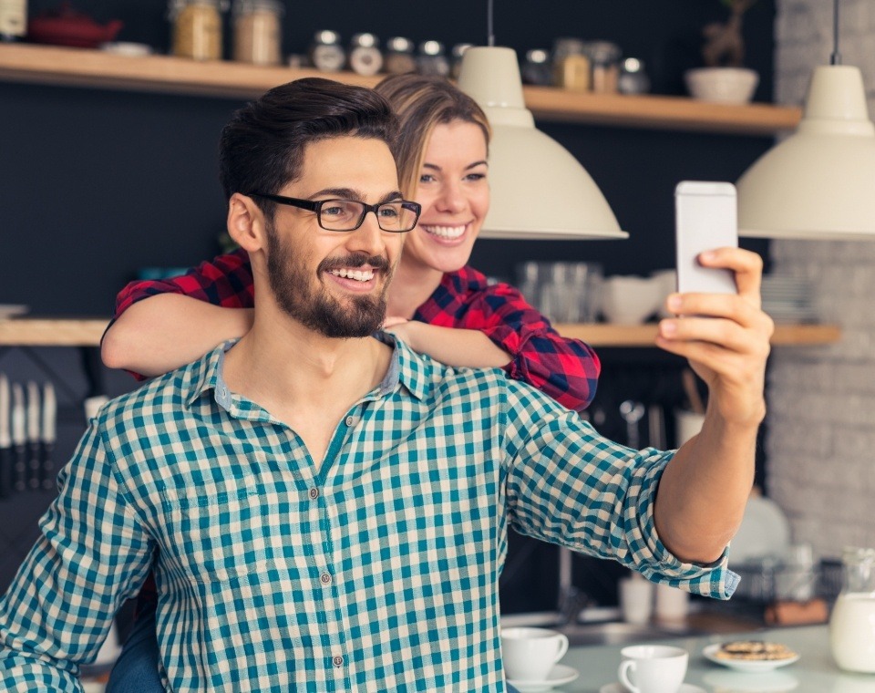 Man and woman smiling after receiving dental services