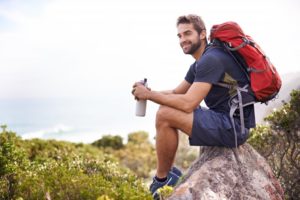 a man smiling while on a hike 