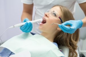 Dentist using intraoral camera for woman's examination