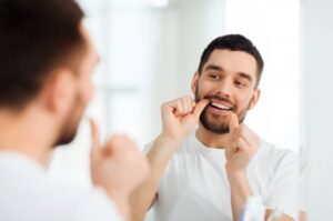 Man flossing around his dental implant